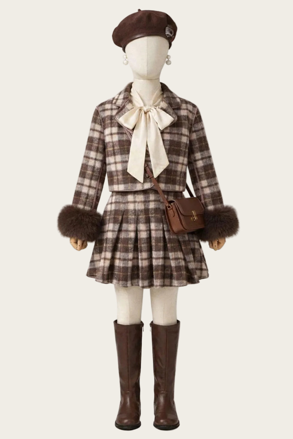 Mannequin wearing a plaid outfit with a bow, beret, and brown boots on a white background